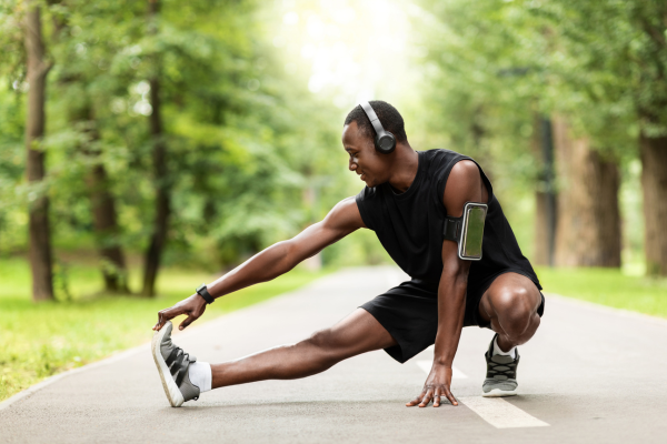 Man stretching calves on road