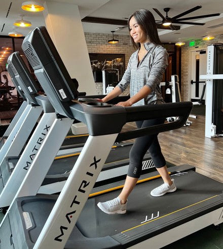 Woman walking on treadmill inside gym