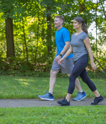 Man and woman taking a walking break while running