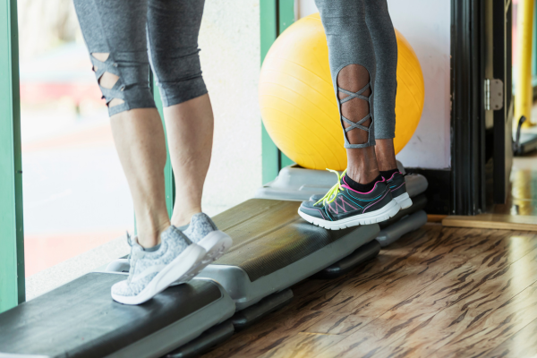 Two people performing toe raise exercise for metatarsalgia