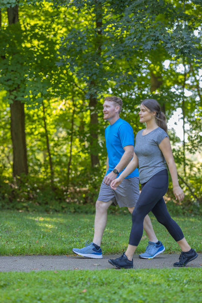 man and woman walking on an outdoor running trail