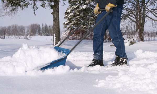 Person shoveling snow wearing snow boots