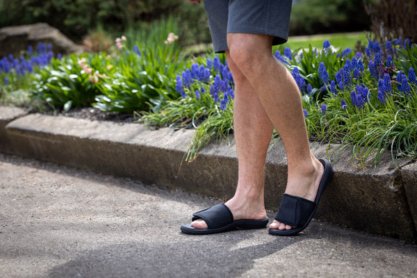 Man wearing orthotic slide sandals outside