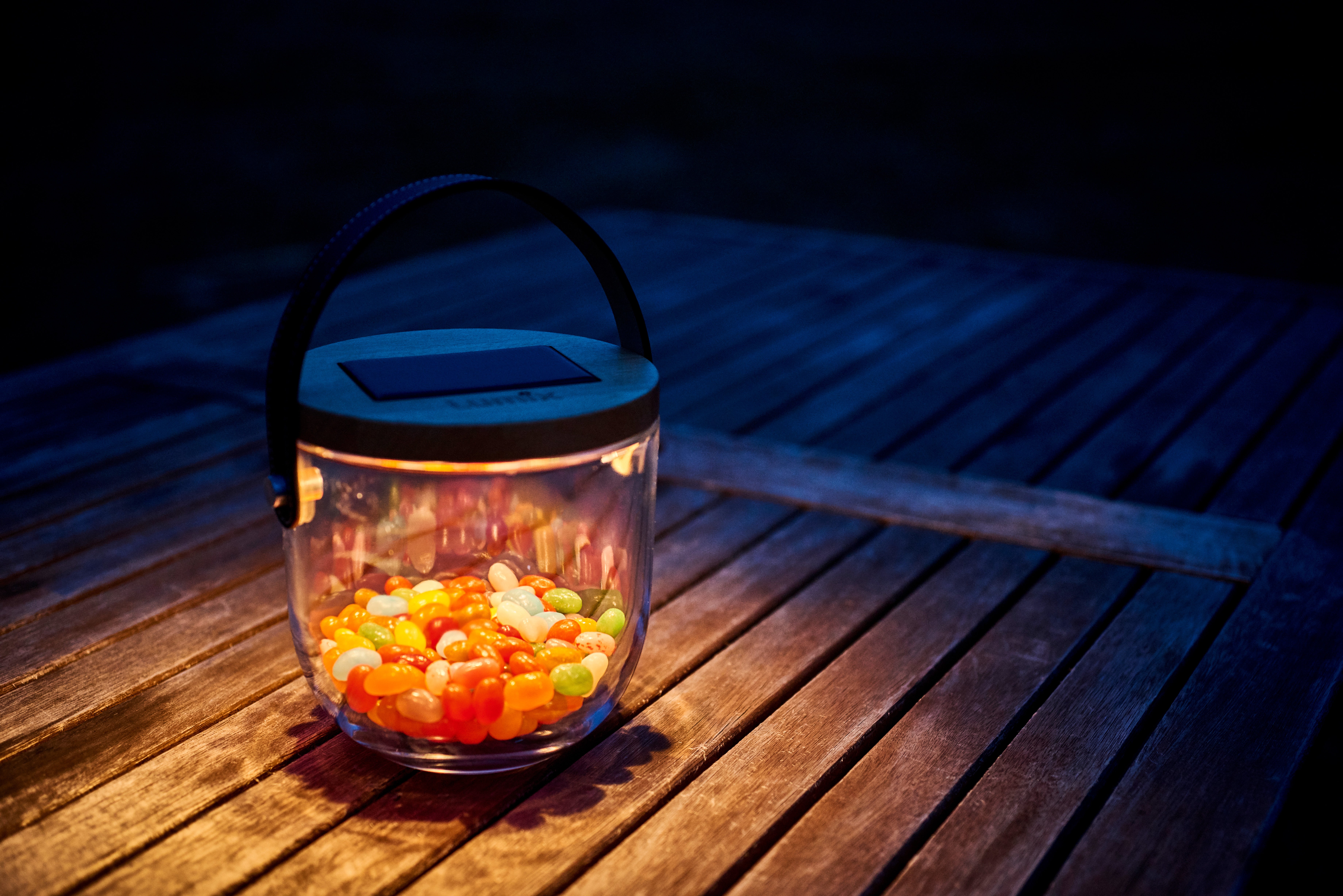 Krinner Lumix Deco Glass gefüllt mit bunten Jelly Beans leuchtend bei Nacht