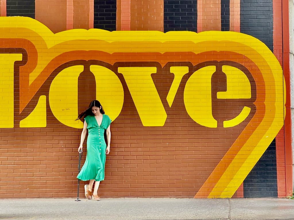 Marissa with cane in front of LOVE mural