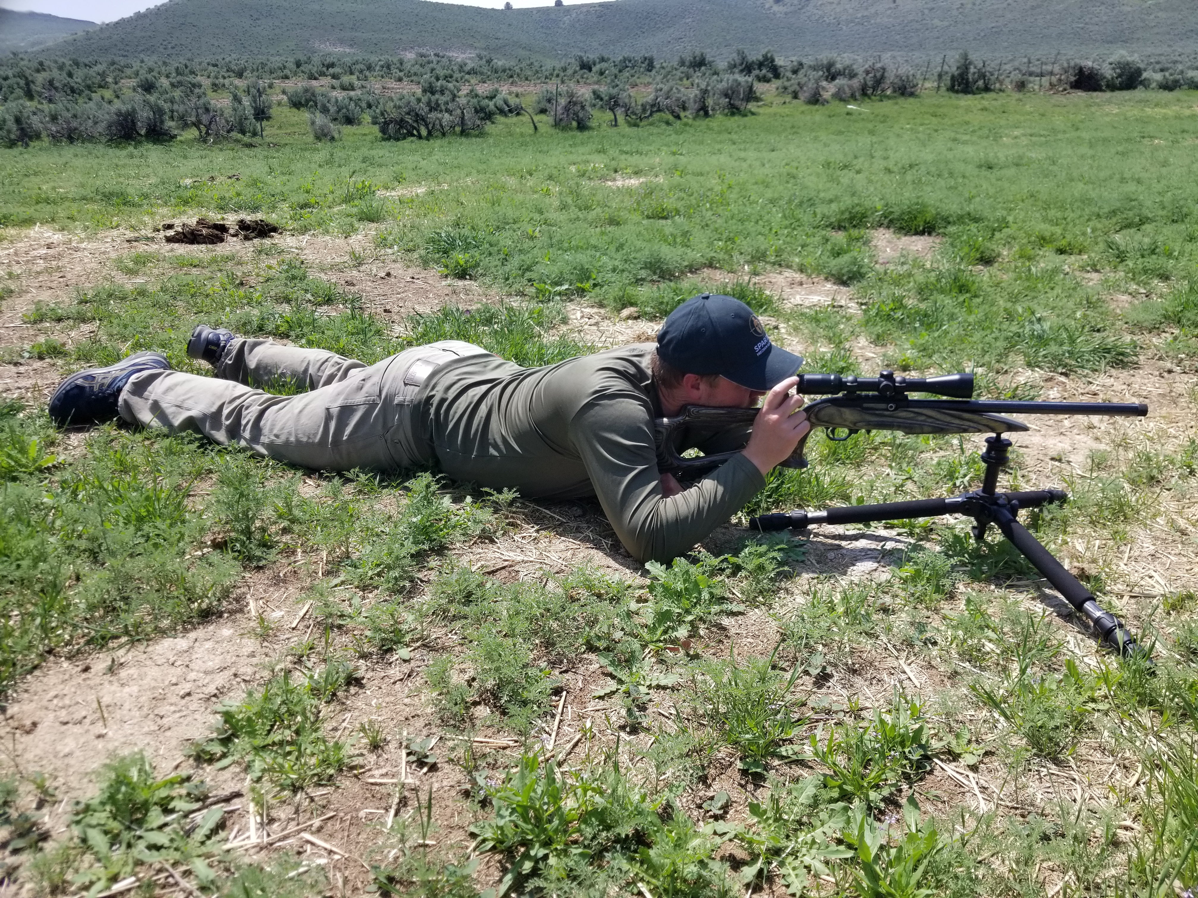 Brad in a prone position, using a .22 LR, mounted on the Ascent tripod with the legs splayed in its outermost position.