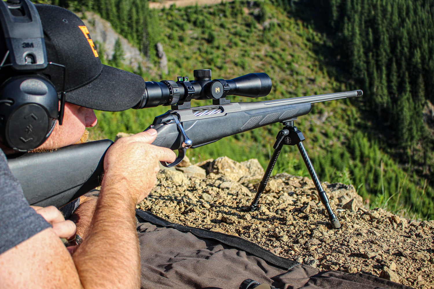 Justin builds a prone shooting position with his Tikka rifle, overlooking a clearcut in Washington