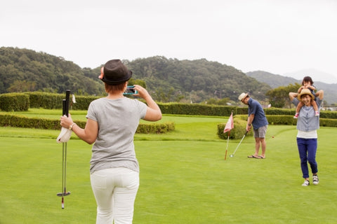 家庭高尔夫球场一个儿童三个成人女人带相机