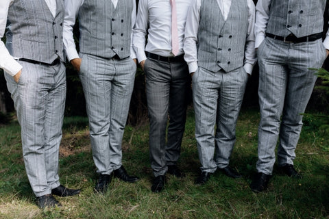 stylish-groom-his-groomsmen-stand-grass