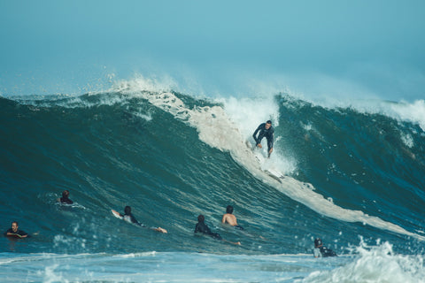 surfeur sur une vague qui porte une combinaison neoprene ONE SURFING CO