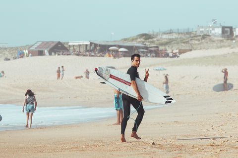 surfeur qui courent sur la plage avec une combinaison neoprene