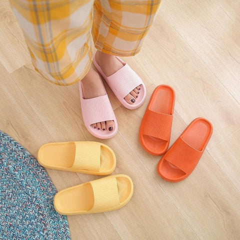 woman in pajamas choosing between 3 pairs of slides