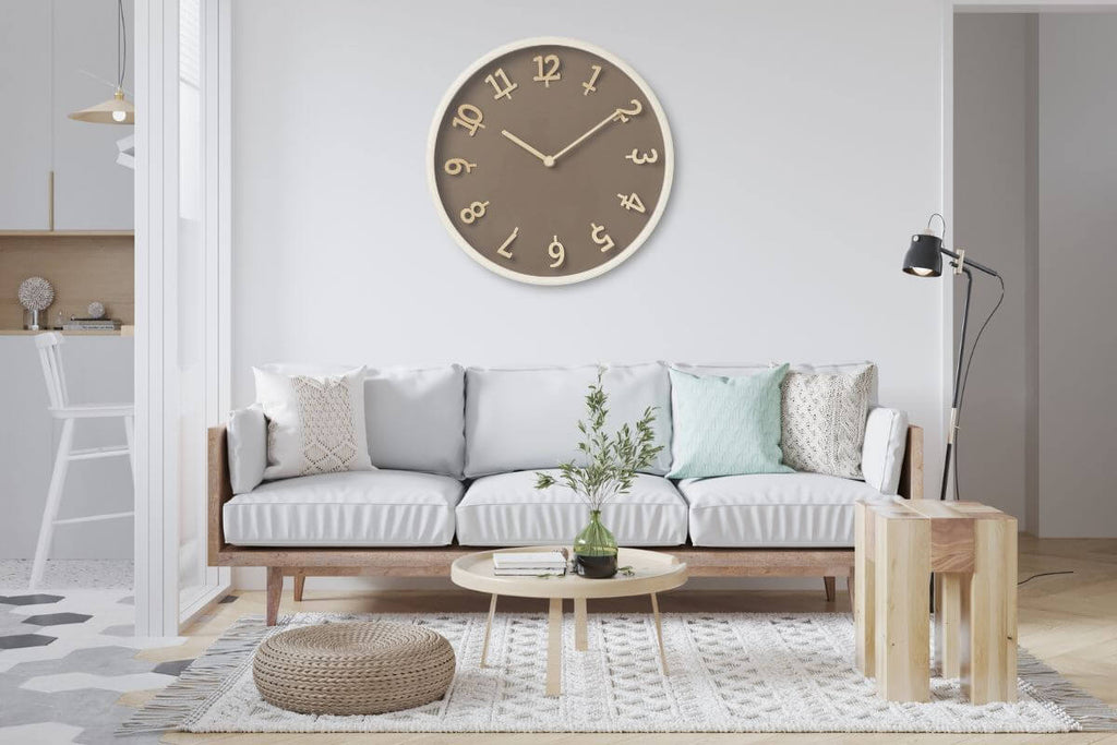 Oversized brown clock above white sofa