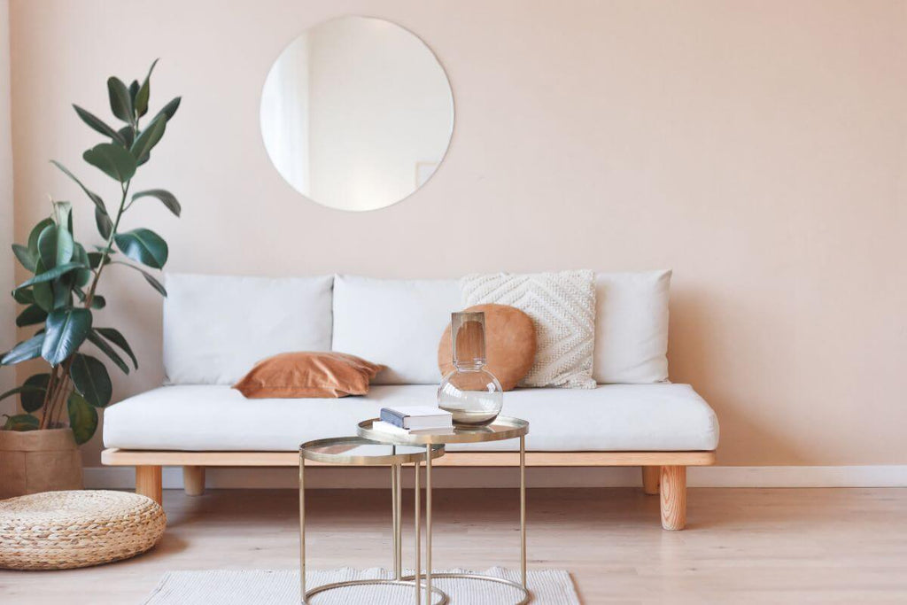 Round mirror above white sofa