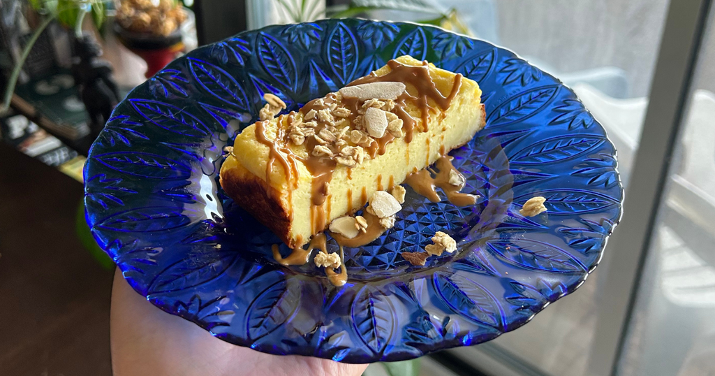 Cheesecake topped with granola and a cookie butter drizzle