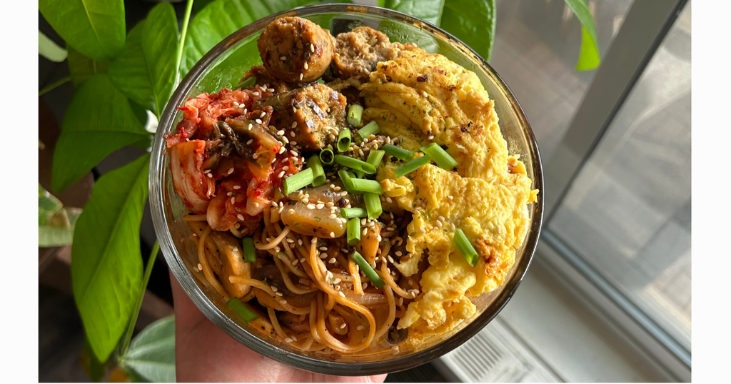 Gochujang noodles with eggs, sausage, kimchi, green onions, and sesame seeds