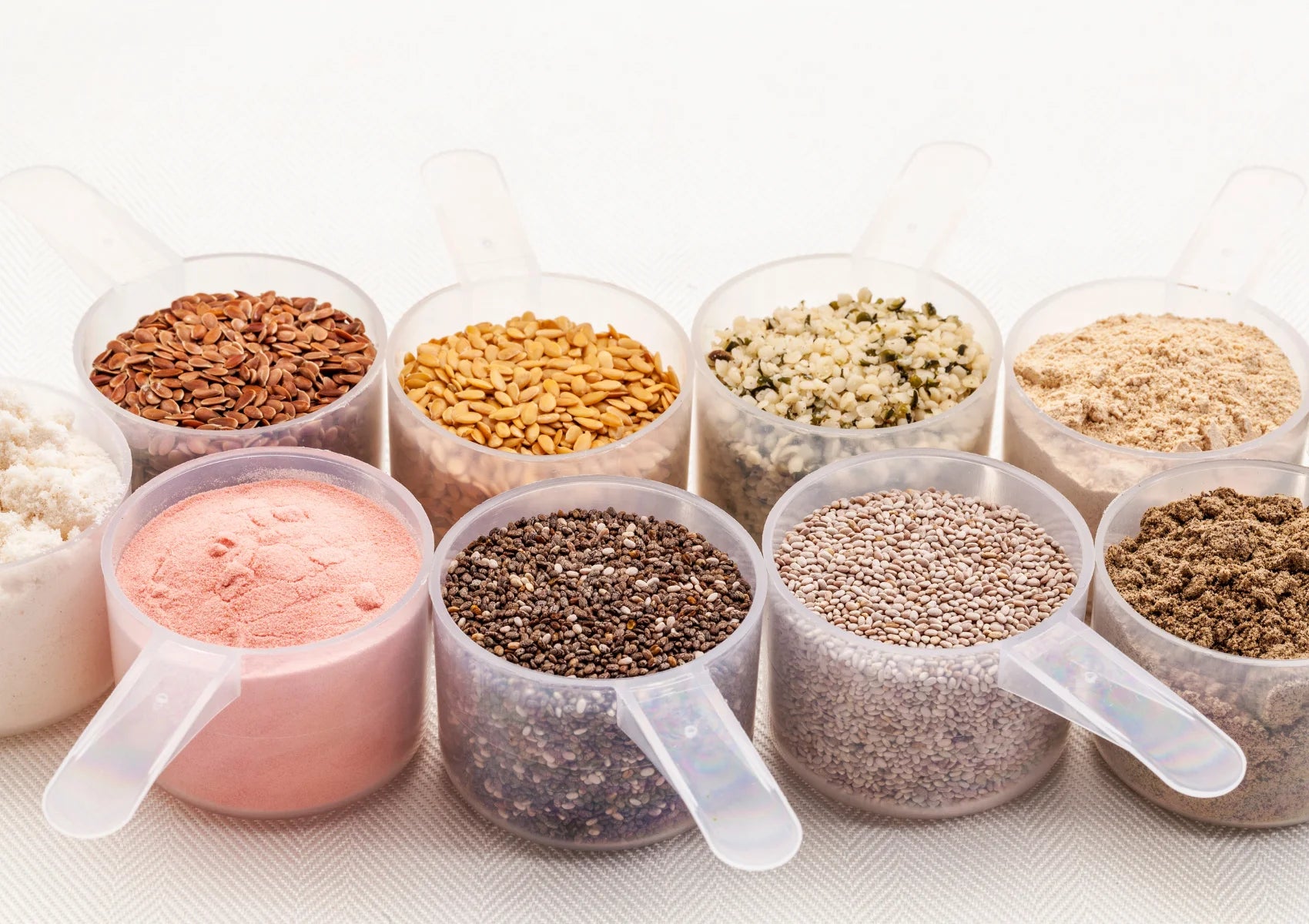 assortment of chia seeds, sunflower seeds, nuts and powders in scoops