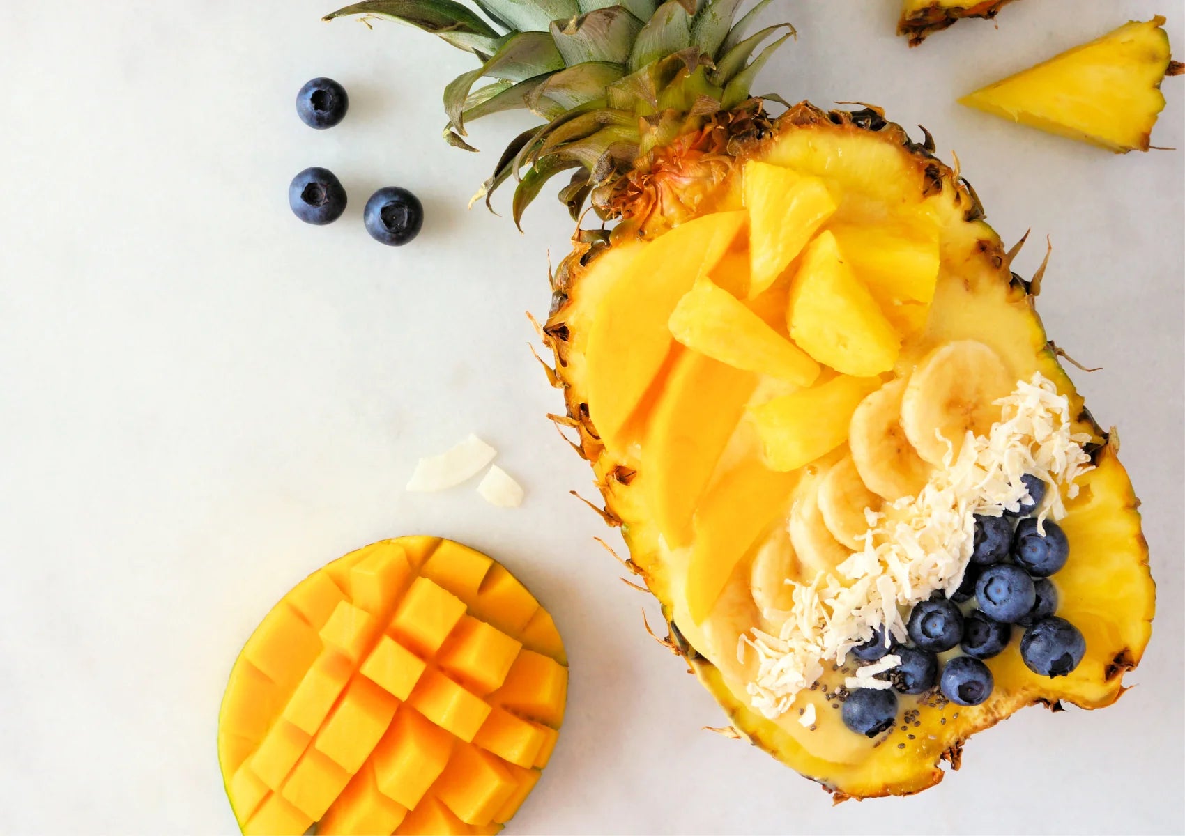 pineapple, banana, mango, blueberries fruit on a table