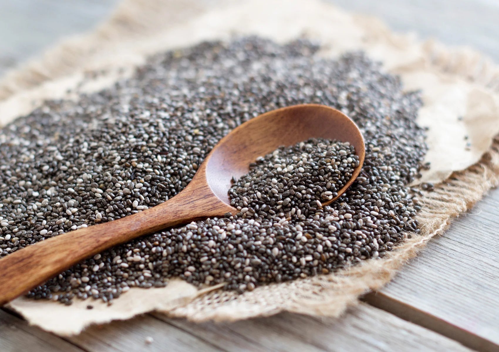 chia seeds with wooden spoon on a wooden table