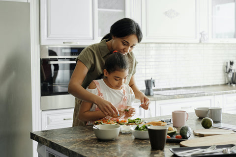 A family joyfully cooking together in the kitchen, sharing smiles and laughter while preparing a meal.