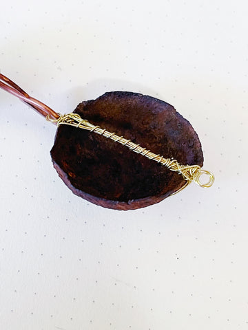 Half domed rusted metal object wire wrapped with brass