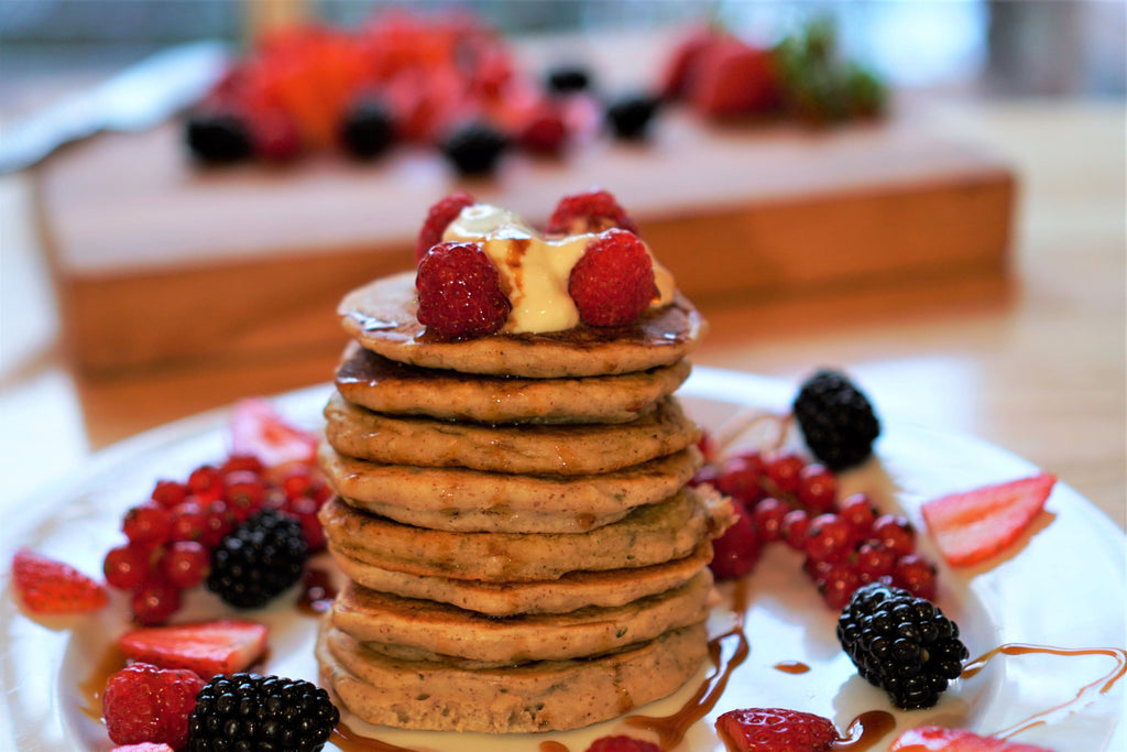 image of a delicious stack of pancakes topped with berries and syrup