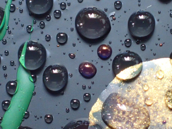 Droplets of water on top of black wax