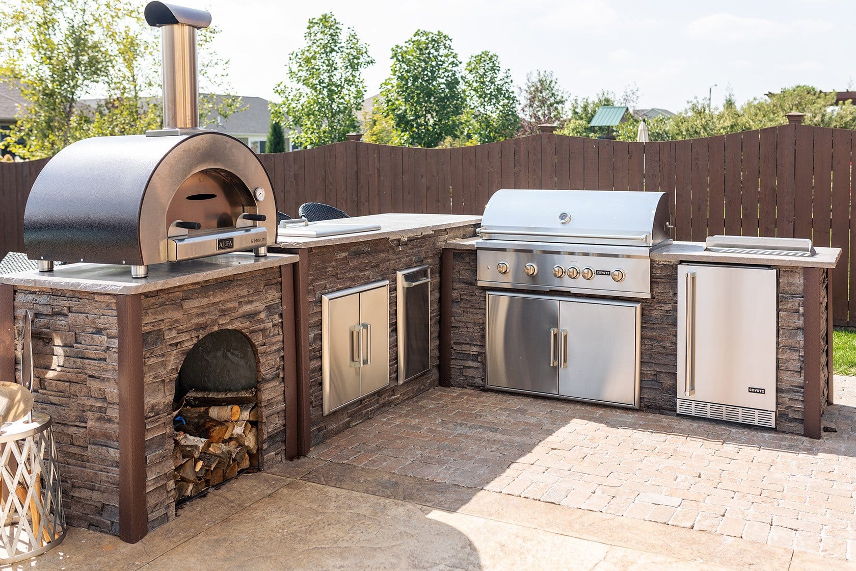 https://cdn.shopify.com/s/files/1/0566/2453/t/47/assets/outdoor-kitchen-with-wood-fired-pizza-oven-and-fridge-1-1653687691781.jpg?v=1653687695