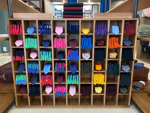 Colourful Socks and Ties arranged in a wooden shelving unit