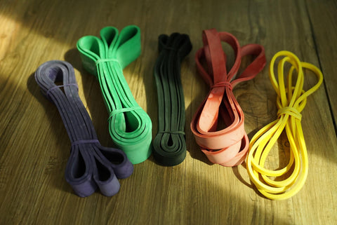 Five resistance bands in purple, green, black, orange, and yellow - Fluid X