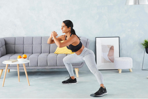 A woman working out in her living room with gliding discs under her feet - Fluid X