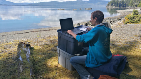 Robert Szucs working at a makeshift workstation on an uninhabited island in Alaska.