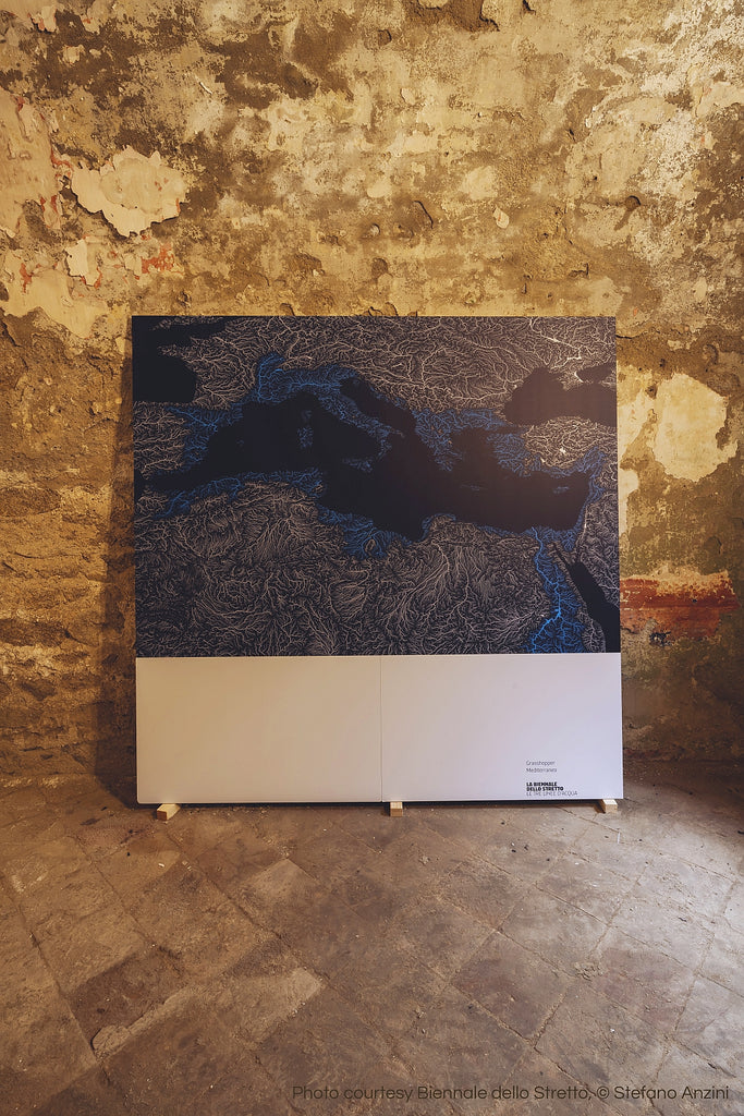 A large panel leaning to a bare wall, showing Grasshopper Geography's river basin map of the Mediterranean that was submitted to the Biennale dello Stretto in 2022.