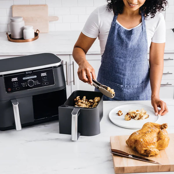 kvinde med airfryer og kylling i køkken