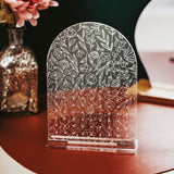 Floral print free standing clear acrylic Earring Holder sitting on a table top