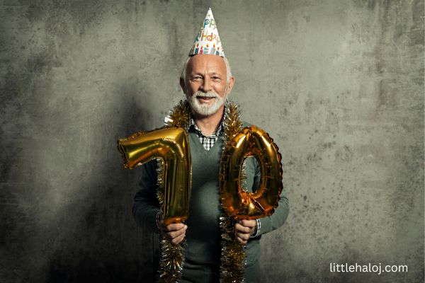 Man holding 70th Birthday balloons