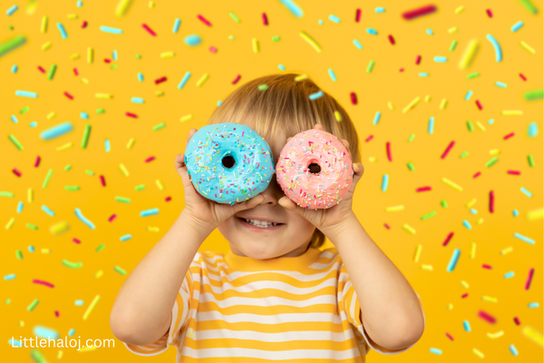 child smiling with donuts over his eyes as a joke