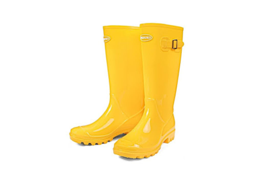 The DKSUKO Women's Tall Garden Boots in yellow with black buckles and white brand labels