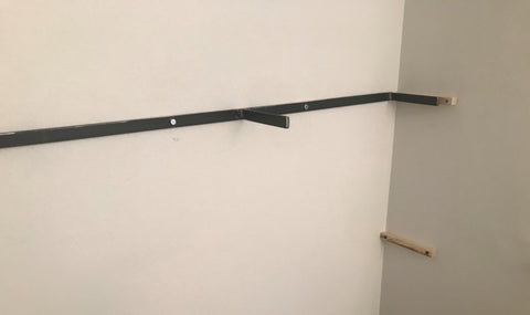 Steel bracket and wood cleat on wall at 1 end