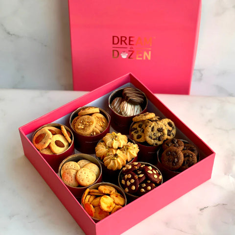 Box of almond, peanut butter, choco-chip, oreo cookies, along with cheese crackers, greeting card and a reusable rigid box. 