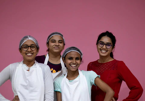 Dream a Dozen Founder and CEO and Chefs smiling at the camera for a team picture. Happy. Inclusive. All Women Kitchen.