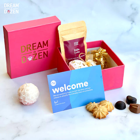 A Pink-themed Christmas box containing Butter Cookies,  Gourmet Chocolates, Handmade Scented Candle, Greeting Card, and Re-Usable Rigid Box