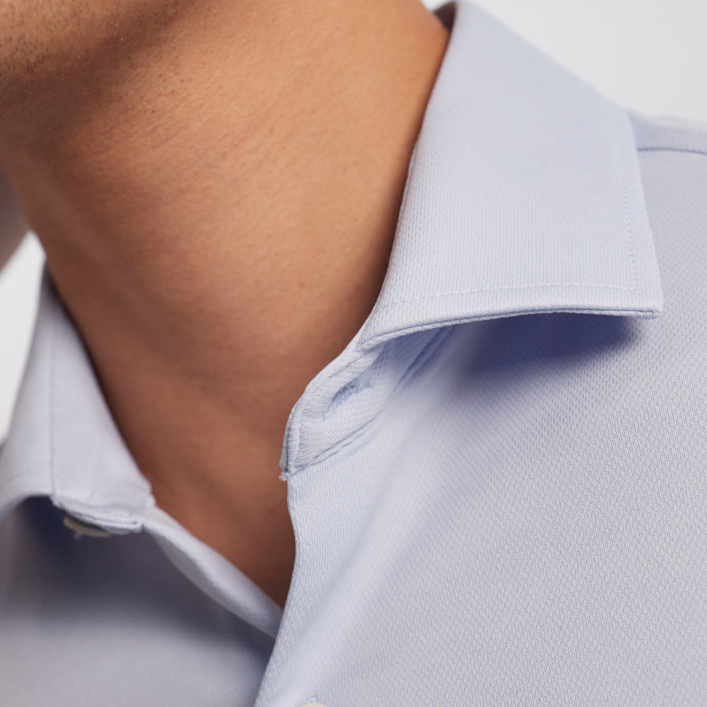 Detalle del cuello de una camisa de hombre azul celeste de tejido sepiia