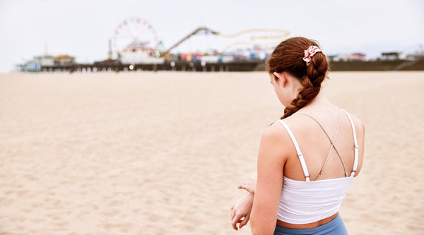 girl with her back to camera on beach with nda sports bra