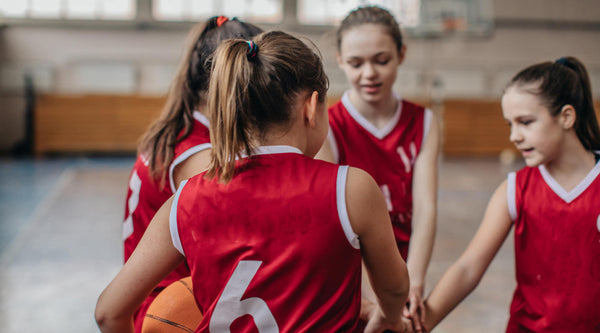 teenage girls huddling before a basketball game