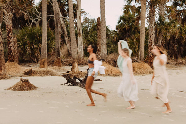 girls running down the beach having fun