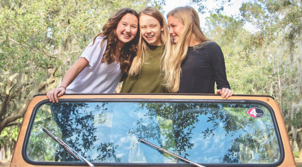 3 teenage girls standing in a jeep smiling - What is a Nipple Concealing Bra?