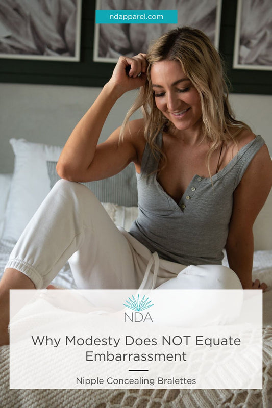 woman sitting on her bed looking down smiling