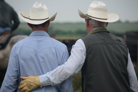 Wellborn 2R Ranch Cowboy Earl Wayne Reese on the right putting a grateful arm around a cowboy.