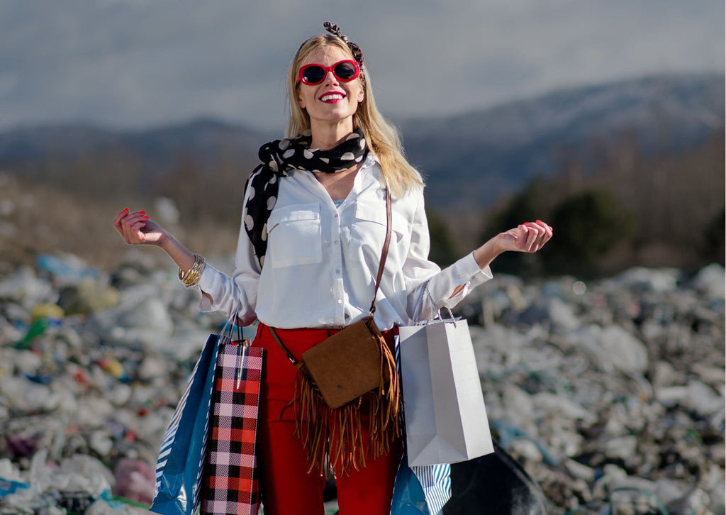 Woman carrying shopping bags and smiling while stood on landfill